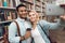 Ethnic indian mixed race guy and white girl in library. Students are taking selfie.