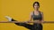 Ethnic Indian smiling happy young flexible woman enjoy stretching in yellow studio. Ballerina dancer acrobat lady sport