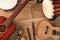 Ethnic musical instruments set: tambourine, wooden drum, brushes, wooden sticks, maracas and guitars laying on wooden