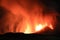 Etna durante suggestiva eruzione di notte con grandi emissioni di vapore nel cielo notturno dal cratere della cima del vulcano del