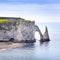 Etretat Aval cliff and rocks landmark and blue ocean . Normandy, France.