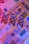 EU currency. Two hundred euro bills close-up in purple neon light. Money colored background.Inflation of money in the EU