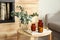 Eucalyptus branches, aromatic reed air freshener and candles on wooden table in living room. Interior element