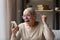 Euphoric laughing old grandmother celebrating online lottery win.