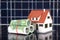 Euro banknote and house model on solar panel background