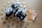 Euro banknotes, coins and a camera on a light wooden background.