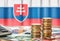 Euro banknotes and coins in front of the national flag of Slovakia