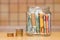 Euro banknotes in a glass jar, columns of coins close-up. The kitchen background is blurred.