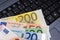 euro banknotes over laptop keyboard