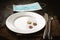 Euro cents coins on empty plate and medical mask on black background. Lack of money, poverty and unemployment concept