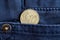 Euro coin with a denomination of 10 euro cents in the pocket of dark blue denim jeans