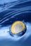 Euro coin falling to the water.