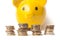 Euro coins piles on yellow piggy bank on white backgr