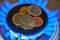 Euro coins on top of gas hob. Gas stove with money. Expensive natural gas