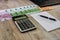 Euro, notebook, calculator and part of the laptop on a wooden background