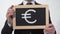 Euro symbol drawn on blackboard in businessman hands, European currency, finance