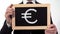 Euro symbol drawn on blackboard in businessman hands, European currency, finance