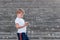 Europe alone a Boy in a white t-shirt enjoys smartphone on ladder . Kids and smart phone, children and the Internet