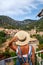 Europe Spain travel vacation. Happy woman in sun hat enjoying at view on village in the Tramuntana mountains. Amazing