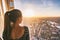 Europe travel woman looking at sunset view of London city skyline from the window of highrise skyscraper tower, famous