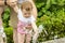 European baby girl playing with jets of water in a fountain. Baby wets her hands in the fountain. Caucasian girl playing with