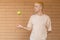 European blond guy tossing a green apple on the side and catching it with his hand