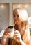 European blond smiling young woman drinking latte in cafe