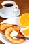 European breakfast: cup of coffee, toasts, jam, butter and orange