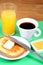 European breakfast: cup of coffee, toasts, jam, butter and orange juice
