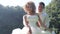 european bride dances and waves wedding dress against mangrove trees