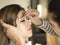 European brunette woman having a professional eyebrow correction procedure. Working with tweezers master class