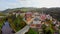 European castle with moat river, bridge, colorful roofs aerial