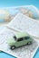 European classic car in miniature driving through a road map. Space for text