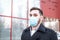 European coronavirus. Portrait of caucasian man wearing facial hygienic mask, respiratory protection mask outdoors. Virus,