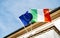 The European flag of Europe and Italian flag waving low angle view