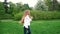 European girl with long curly hair running in the park. Very long hair fluttering in the wind, slow motion