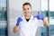 European happy woman scientist in a medical gown and rubber gloves holds a chemical flask in hand