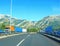 European highway in the mountains. A road with markings leading to the mountains. Bridge with blue pylons. Trucks on the road.