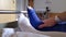 European man with Achilles tendon rupture laying in hospital bed after operation with special shoe and crutches room