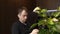 European Man Sitting in Cafe with Cup of Coffee and Watch the News on His Phone