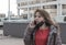 European middle-aged woman hears disturbing news on the phone against the backdrop of modern buildings in the city. Depth of field