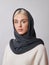 European Muslim woman with a blonde hair in a headscarf shawl dressed on her head. Beautiful girl in sweater with soft skin,