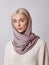 European Muslim woman with a blonde hair in a headscarf shawl dressed on her head. Beautiful girl in sweater with soft skin,