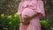 European pregnant girl in a pink dress gently touches her big stomach with her hands, stands on the back green garden