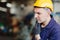 European Russian worker thinking handsome factory man wearing helmet safety suit and hand groove