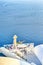 European Scenic Destinations. Pale Houses And Open Air Restaurant of Oia Village in Santorini in Greece with Sailing Boats on