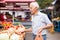 European senior buying potatoes in market