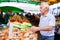 European senior buying potatoes in market