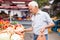 European senior buying potatoes in market