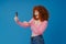 European smiling woman with red curly hair using mobile phone